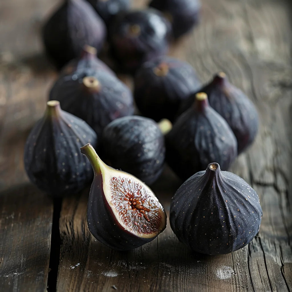 Black Mission Figs on a wooden surface with one cut in half